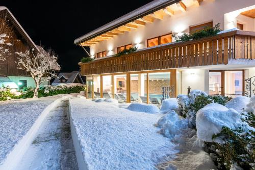 una casa coperta di neve di notte di Hotel La Perla a Ravascletto