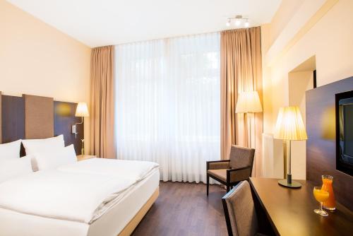 Un pat sau paturi într-o cameră la Villa Hotel Frankfurt by MZ HotelCollection