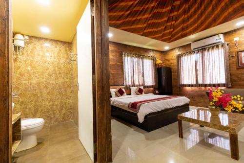 a hotel room with a bed and a bathroom at Rainforest Resort and Spa, Igatpuri -Nature's Luxury Awaits in Igatpuri