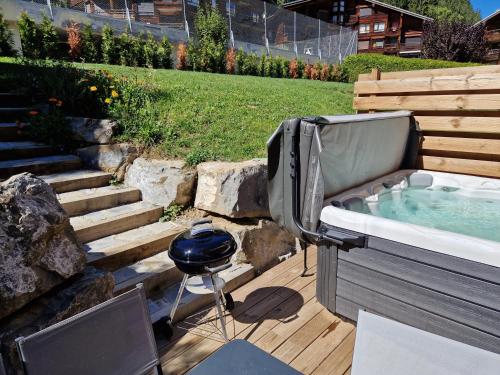 een hot tub en een grill in de achtertuin bij Chalet Delphinette - Spa privatif in Morzine