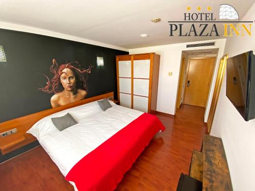 a bedroom with a bed with a painting on the wall at Hotel Plaza Inn in Figueres