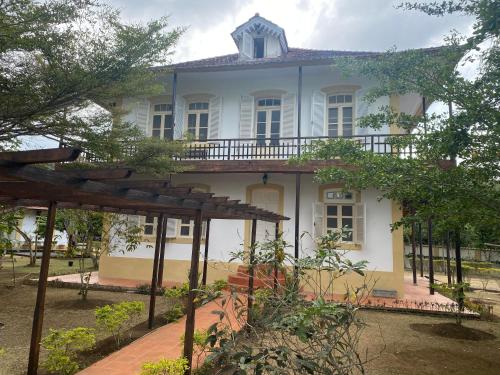 a large white house with a roof at Roça Vale dos Prazeres in São Tomé