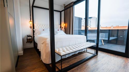 a bedroom with a white bed and a large window at Hills Hotel Lisboa in Lisbon