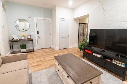 un soggiorno con una grande TV a schermo piatto di Spacious 2 bed 2 bath Downtown OTR condo minutes walk to the Reds Bengals stadium & more! a Cincinnati