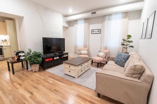 un soggiorno con divano e TV a schermo piatto di Spacious 2 bed 2 bath Downtown OTR condo minutes walk to the Reds Bengals stadium & more! a Cincinnati