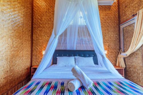 um quarto com uma cama e uma rede mosquiteira em Atuh Forest Cottage em Nusa Penida