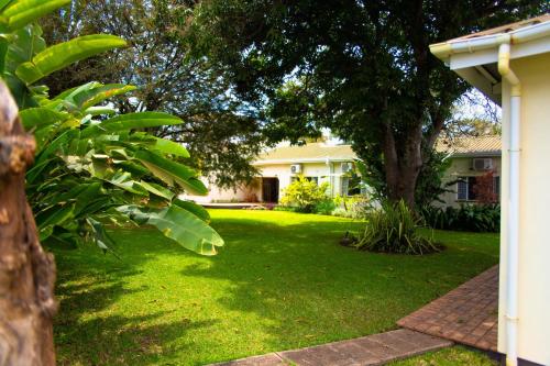 una casa con un patio verde con un árbol en Burley House by Ulendo, en Lilongwe