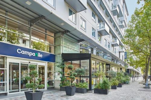 un magasin devant un bâtiment avec des plantes en pot dans l'établissement Hotel Campanile Paris-Bercy Village, à Paris