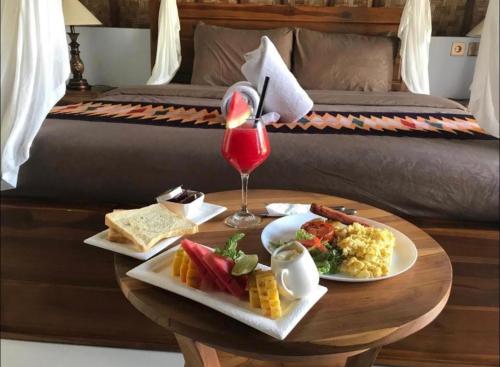 uma mesa com dois pratos de comida e uma bebida em Bintang Bungalow em Nusa Penida