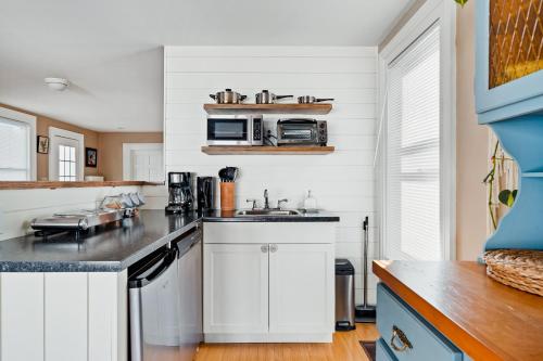 a kitchen with white cabinets and a counter top at Sunroom on Maple in Picton