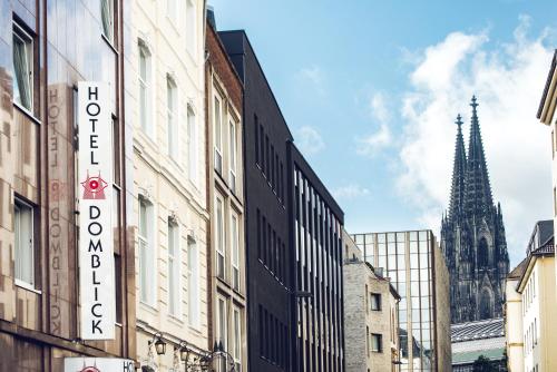 een straat met gebouwen en een kerk bij Hotel Domblick Garni in Keulen