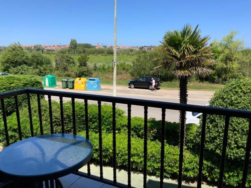 d'un balcon avec une table et un palmier. dans l'établissement PUENTE DE DICIEMBRE OFERTA piso a pie de playa, ideal mascota, à Noja