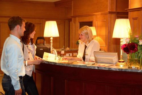 a group of people standing around a reception counter at Hotel Garni in Bad Schallerbach