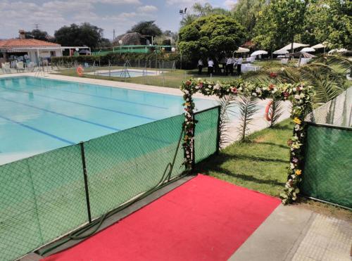 einen Pool mit rotem Teppich neben einem Zaun in der Unterkunft Hotel Peña Cruz in Malpartida de Cáceres