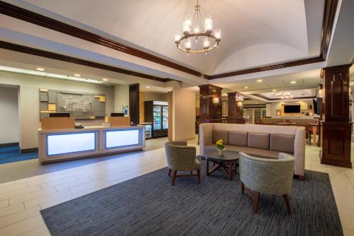 eine Lobby mit einem Sofa, Stühlen und einem Tisch in der Unterkunft Holiday Inn Express State College at Williamsburg Square, an IHG Hotel in State College