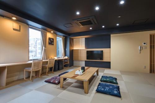 - un salon avec une table, des chaises et une télévision dans l'établissement Hotel Sugicho, à Kyoto