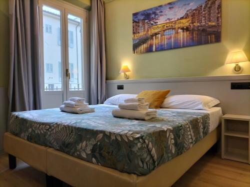 1 dormitorio con 1 cama con toallas en Hotel Camilla Firenze, en Florencia