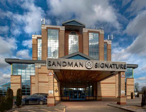 Ein großes Gebäude mit einem Schild, das der Leser unterschreibt in der Unterkunft Sandman Signature London Gatwick Hotel in Crawley