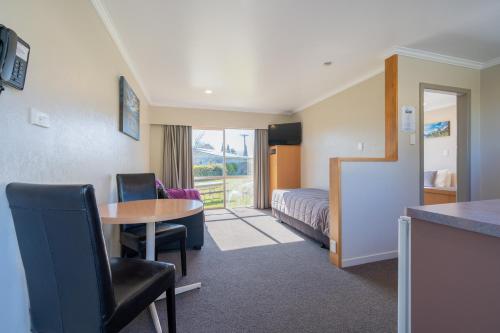 una camera d'albergo con tavolo e letto di Te Anau Motel & Apartments a Te Anau