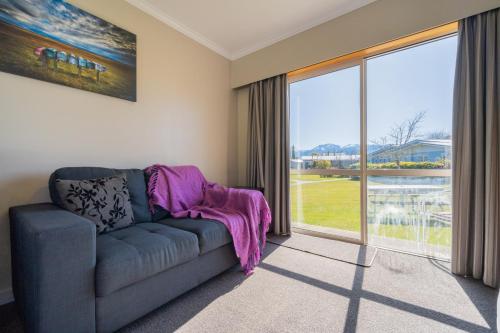 un soggiorno con divano e una grande finestra di Te Anau Motel & Apartments a Te Anau