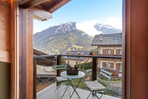 een balkon met een tafel en stoelen en een berg bij Aria di Casa Reit in Valdisotto