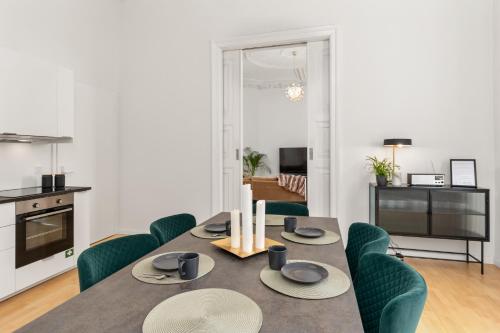 a dining room with a table and green chairs at HOMEY Apartments - Riverside - mit Weserblick und Parkplatz in Bremen