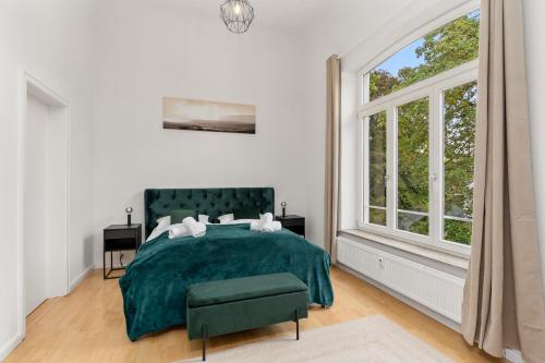 a bedroom with a green bed and a window at HOMEY Apartments - Riverside - mit Weserblick und Parkplatz in Bremen