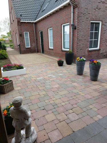 a brick building with a brick courtyard with a statue at De Poldersteeg 