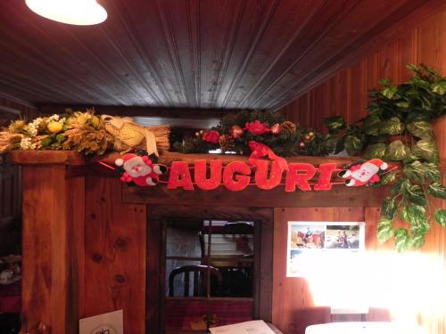 a sign on top of a restaurant with flowers at Le Vieux Rascard Chambres d'Hotes in Champoluc