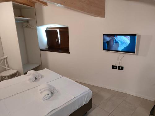 a room with two white beds and a tv on the wall at La Corte Room & Relax in Rovereto