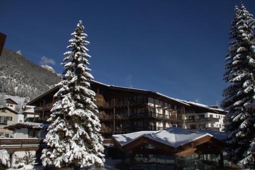 een skihut met sneeuw bedekte bomen voor de deur bij Hotel Trento in Pozza di Fassa