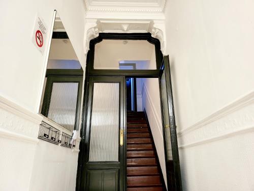 un couloir avec une porte verte dans un bâtiment dans l'établissement Chambre privée au 3e étage sans ascenceur en plein centre de Charleroi, à Charleroi