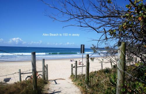 una spiaggia sabbiosa con recinzione e oceano di Alex Beach Cabins and Tourist Park ad Alexandra Headland