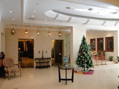 una sala de estar con un árbol de Navidad en una habitación en Shanasheel Palace Hotel, en Baghdād