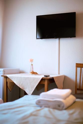 Habitación con mesa y TV en la pared. en Hotel Dalmacija, en Mayen