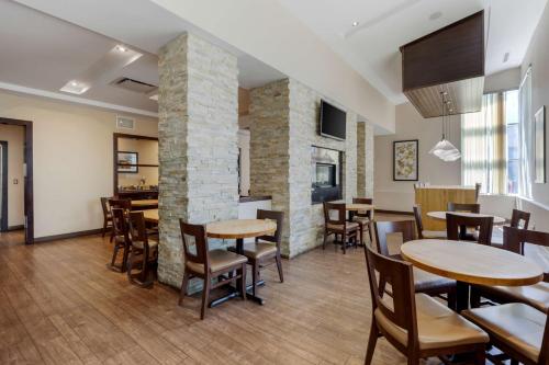 une salle à manger avec des tables, des chaises et une cheminée dans l'établissement Best Western Plus Edmonton Airport Hotel, à Leduc