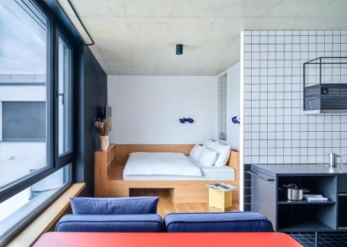 a small room with a bed and a couch at STAYERY Cologne Ehrenfeld in Cologne