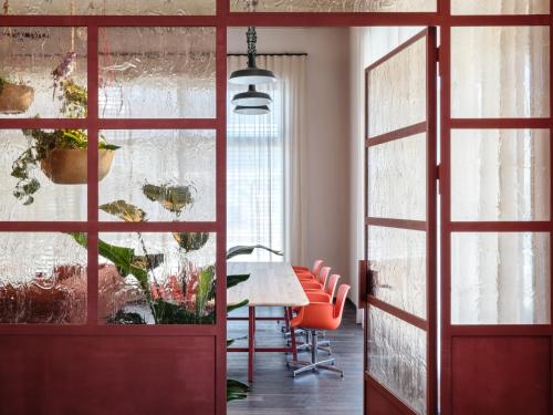 a dining room with red doors and a table and chairs at STAYERY Cologne Ehrenfeld in Cologne