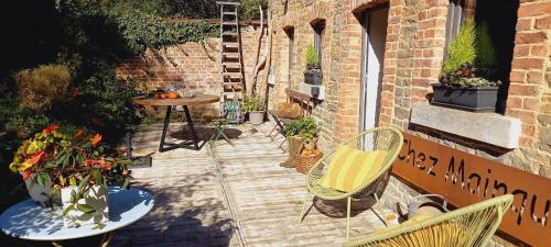 une terrasse avec des chaises, une table et des fleurs dans l'établissement La Faironnière, à Hamoir