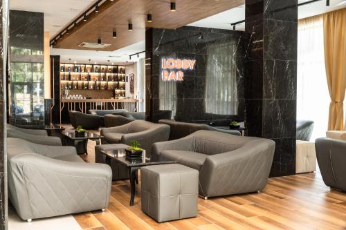 eine Lobby mit Sofas, Tischen und einer Bar in der Unterkunft Santé SPA Hotel in Welingrad