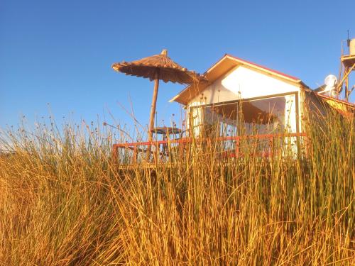 Eine Hütte auf einem hohen Gras in der Unterkunft Uros Titicaca Khantaniwa Lodge in Puno