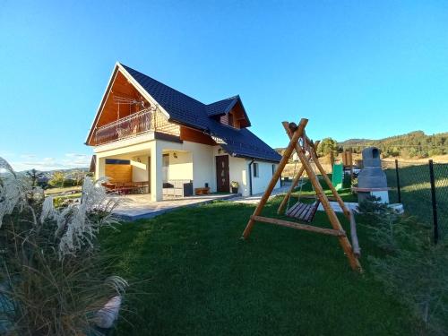 une maison avec un toit bleu au-dessus d'une cour dans l'établissement Domek na Hubce II, à Maniowy