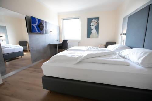 A bed or beds in a room at Das Reinisch Just Rooms