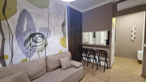 een woonkamer met een bank en een keuken bij Ancora apartment Anja in Novi Sad