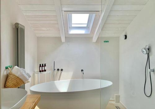 un bagno bianco con vasca e lavandino di Santa Lucia Maccarese - Residenza Agricola a Maccarese