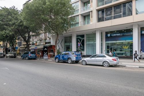 un grupo de coches estacionados frente a un edificio en RK Suite Hotel, en Luanda