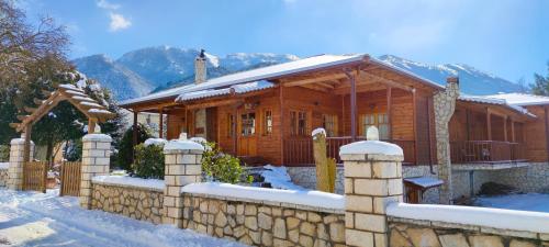 uma casa de madeira com uma cerca na neve em Xylino Chalet em Kalavrita