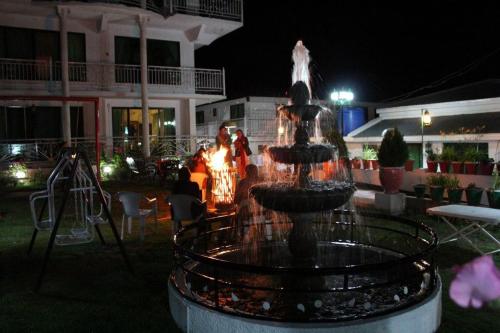 a fountain in front of a house at night at European Complex in Bhurban