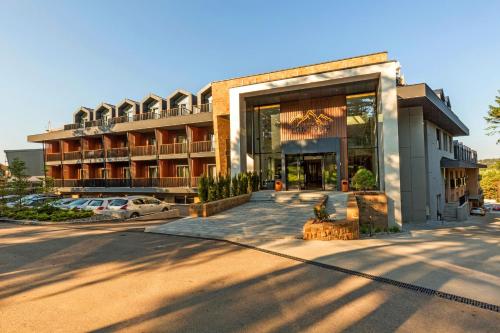 un bâtiment avec un parking en face de celui-ci dans l'établissement Hotel Crni Vrh, à Divčibare