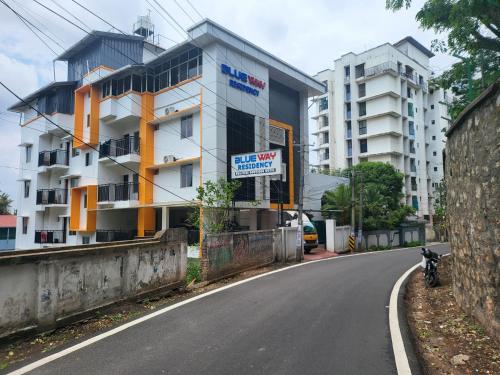 een straat met een gebouw aan de kant van een weg bij BLUEWAY RESIDENCY BUSINESS BOUTIQUE HOTEL in Trivandrum